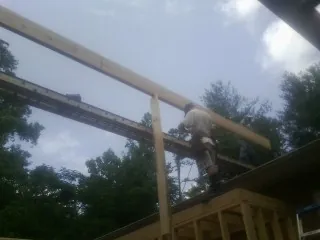 Carpenter setting a ridge beam over a new addition frame — Ice Dam Removal by Roofing Brothers in Readyville