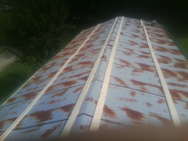 Rusted metal roof panels with new wood purlins before replacement — Storm Damage Roof Repair in Readyville by Roofing Brothers