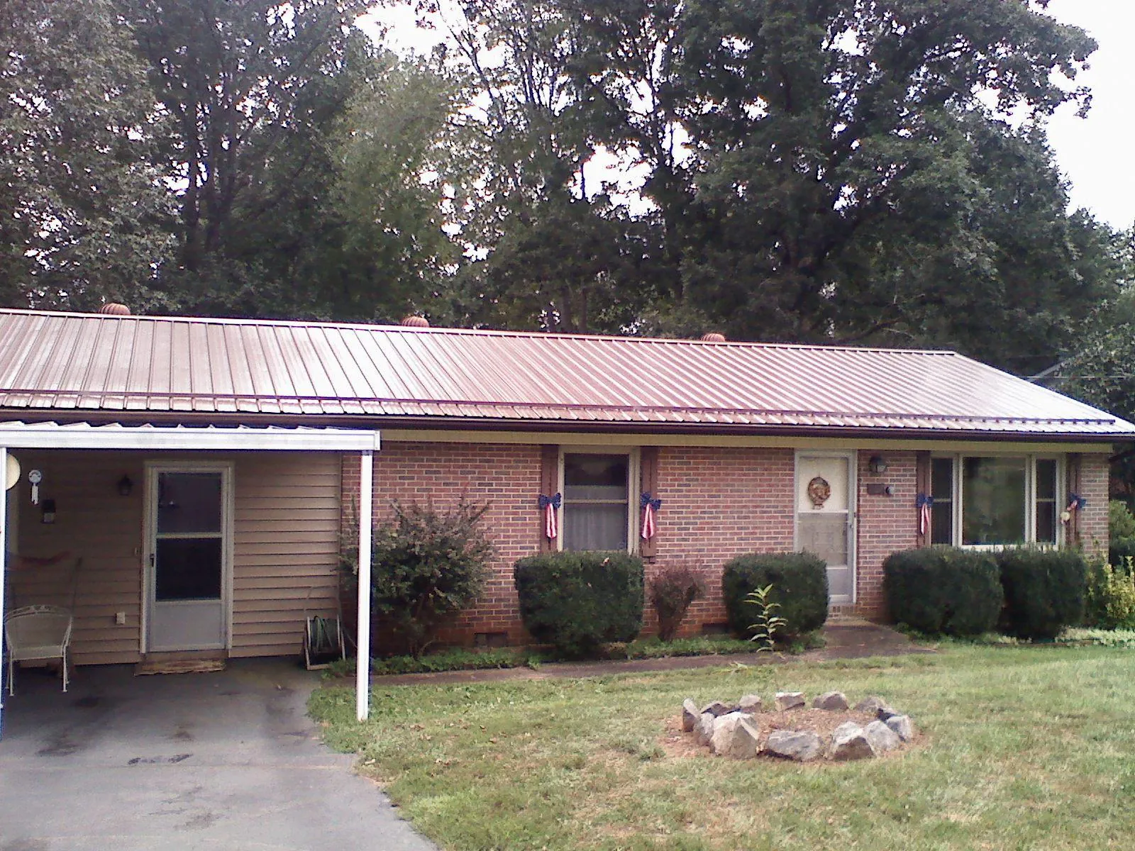 Bronze metal roof and carport on a brick ranch home — Roof Repair work by our crew in Readyville